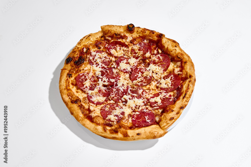 Naklejka premium Pepperoni pizza top view placed on white plate on clean white background. Concept of food delivery, sharing meal, group dining, takeaway menu and restaurant promotion.