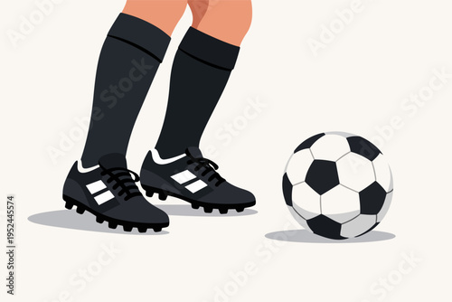 Football player's legs with cleats and socks standing next to a soccer ball on a light background