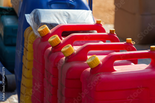 Row of Red Plastic Fuel Jerry Cans for Emergency Resource Storage energy crisis or fuel shortage
