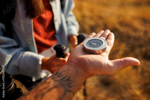 Quadro su tela Close up detail of male hand holding compass for orientation while hiking in nat