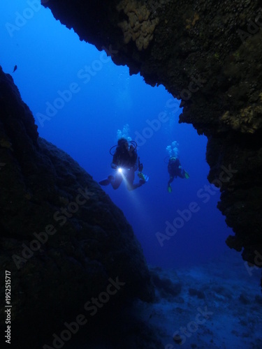 cave diving underwater scuba divers exploring caves and having fun ocean scenery sun beams and rays background