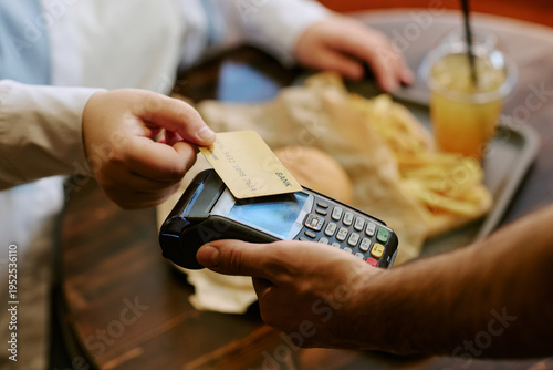 Fotografie Caucasian young adult woman holding credit card making contactless payment on ca