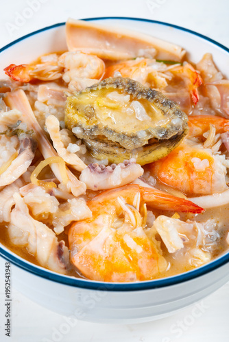 angle view fresh seafood porridge with shrimps and squid and abalone at vertical composition