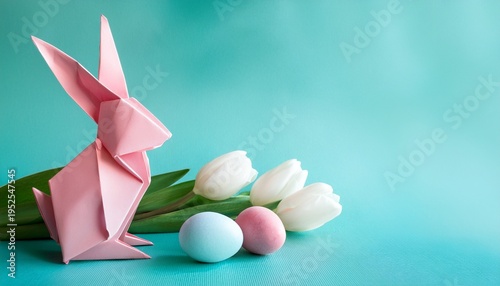 Close-up of pink origami bunny with pastel easter eggs on a pale turquoise background with white tulip flowers and copy space
