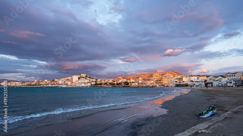 Marseille beach at sunset with colorful clouds over coastal town