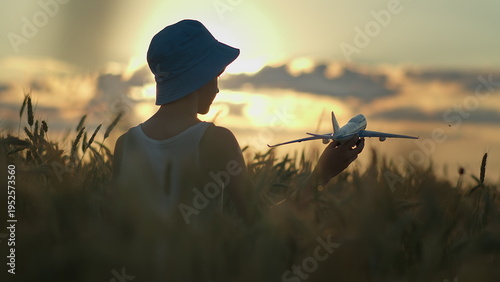 Child Playing with Toy Airplane at Sunset in Nature Field, have fun and enjoy