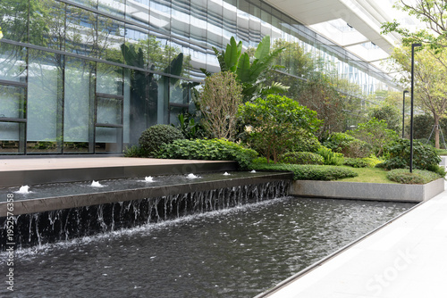 Photos Modern urban water feature with cascading fountain and lush greenery in front of