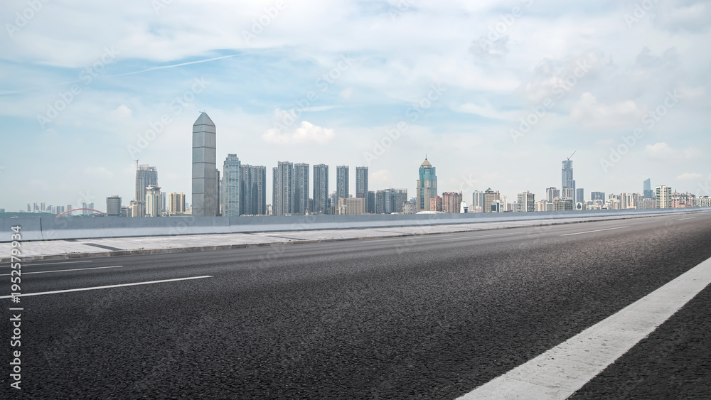 Obraz premium Empty Road Leading to Modern City Skyline