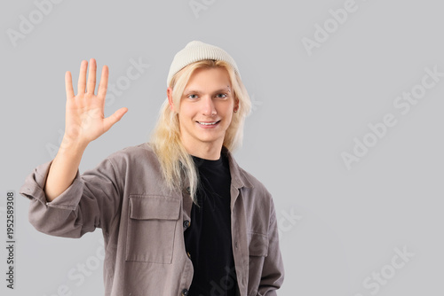 Young blonde man in hat wav...