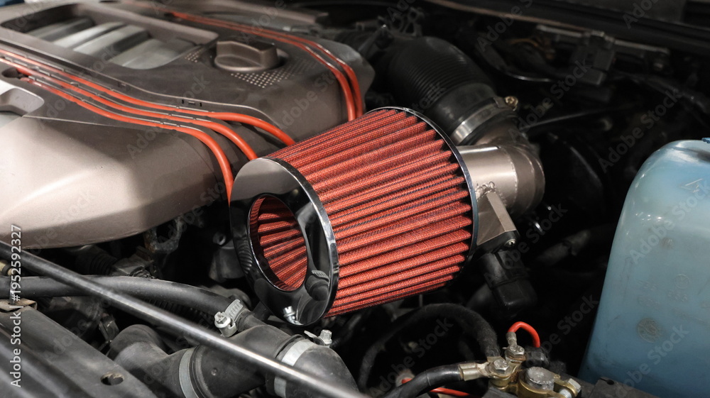 Naklejka premium Close up of a high performance red cone air intake filter in a modified car engine bay