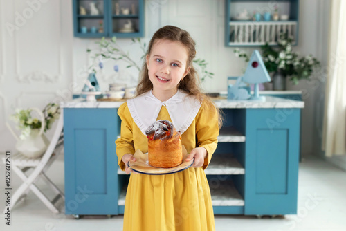Wallpaper Mural Young cute girl with easter cake in hands. Smile child holding easter pastries, celebrating easter and spring. Happy little girl holding a baking with baked cake in her hands on festive house kitchen Torontodigital.ca