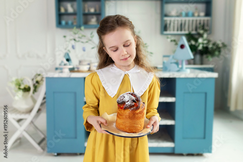 Wallpaper Mural Young cute girl with easter cake in hands. Smile child holding easter pastries, celebrating easter and spring. Happy little girl holding a baking with baked cake in her hands on festive house kitchen Torontodigital.ca