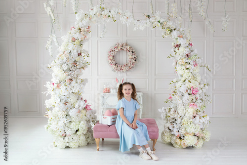 Wallpaper Mural Beautiful little Girl in blue dress with easter egg. Cute small girl is chasing Easter eggs. Hunt Easter eggs. Easter interior design room spring decoration with flowers arch at home. Torontodigital.ca