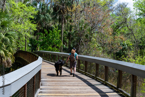 A woman walking her dog in a Florida park