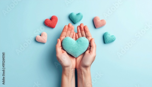 Gentle hands holding knitted heart with pastel colored hearts around, symbolizing love, compassion and emotional warmth in minimal soft aesthetic