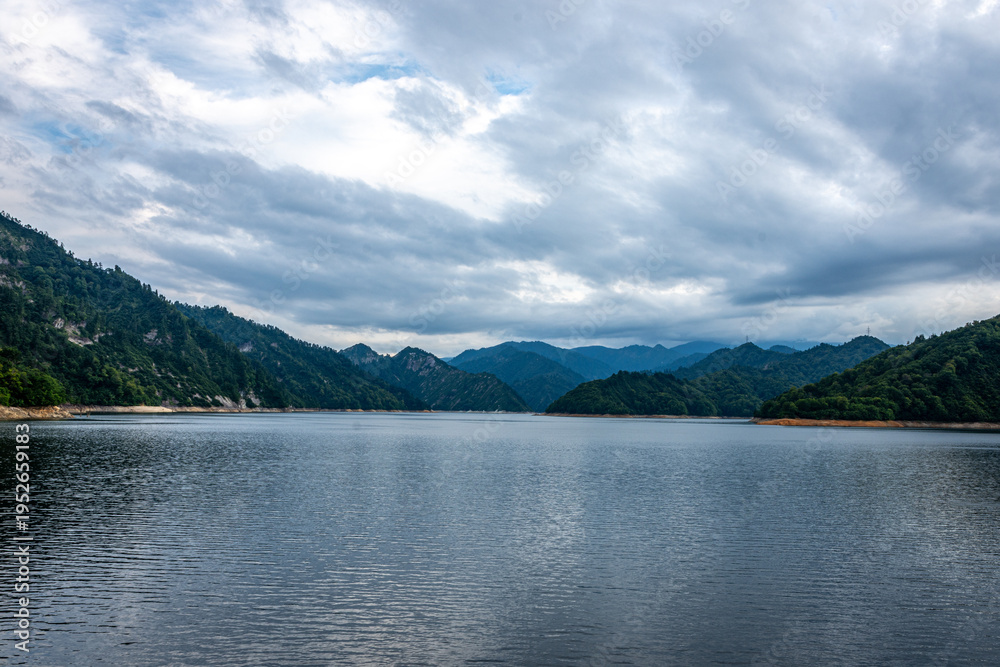 Fototapeta premium 新潟県奥只見湖の雄大な湖面、ドラマチックな曇り空と山並み