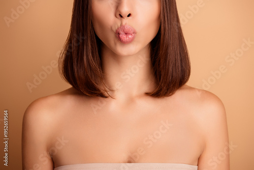 Foto Chic young woman with smooth tanned skin poses with puckered lips showcasing bea
