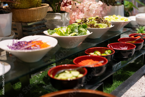 Photography Buffet spread with fresh salads and dipping sauces displayed on glass table in A