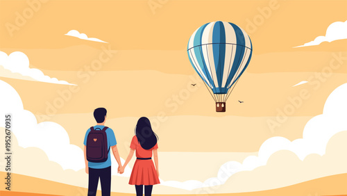 Romantic couple watches a blue and white striped hot air balloon float across a golden sunset sky while holding hands in a beautiful landscape.