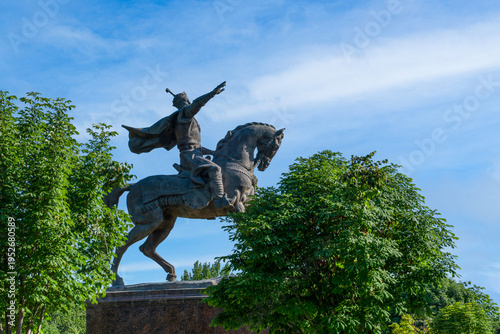Tashkent (Toshkent), Uzbekistan (O'zbekiston) - May 26, 2025: Side view of the Amir Temur Monument, an equestrian bronze statue of the historic conqueror, surrounded by green trees in summer