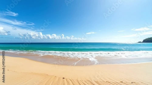 A serene beach scene with gentle waves and a clear blue sky.