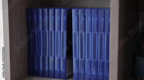Woman Choosing a Video Game Blue Case from a Shelf to Play on Console