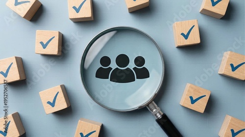 Magnifying glass focusing on a people icon with numerous checkmark wooden blocks, representing human resources evaluation, qualified candidate screening, team organization building, and target audienc