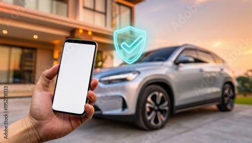 Smartphone with blank screen controlling car remotely with security technology at modern home driveway, suitable for vehicle automation concepts, car insurance