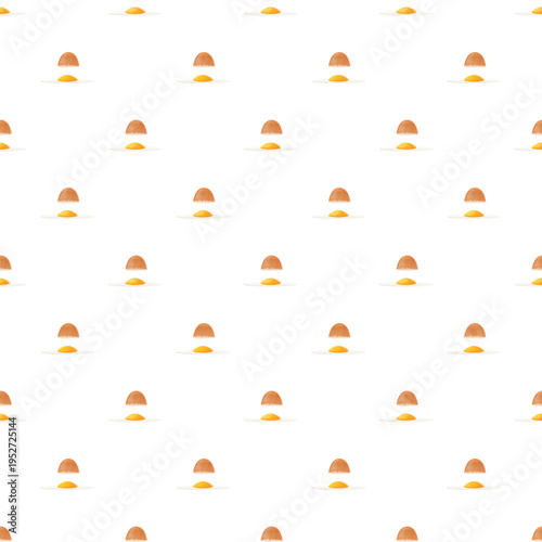 Cracked eggshells with raw egg yolks forming a repeating seamless pattern