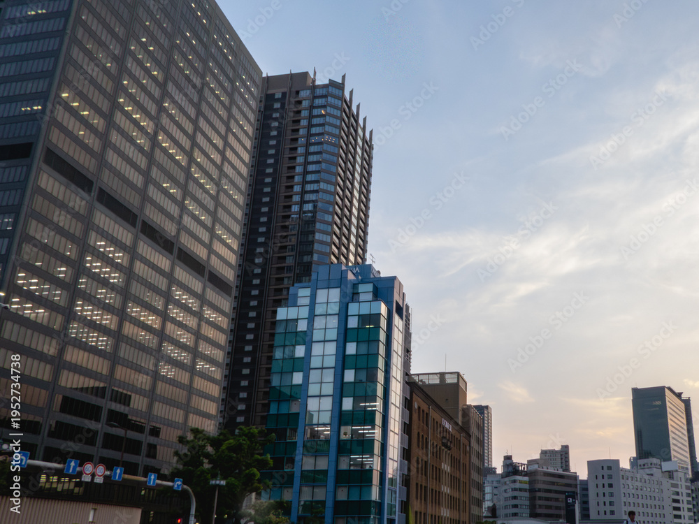 Fototapeta premium 見上げる夕暮れのオフィス街と窓の明かり