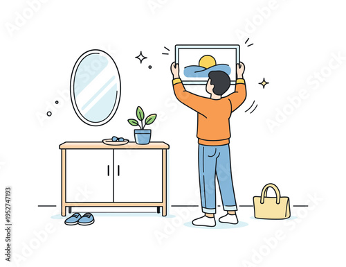 Minimal entryway makeover. A simple mirror and narrow cabinet are aligned against the wall while a person adjusts a framed print above. Gentle motion lines