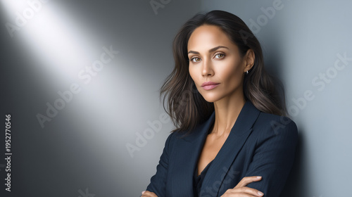 Confident Asian woman posing with arms crossed in modern office  
