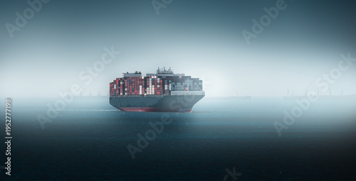 Large container cargo ship sailing through foggy ocean waters transporting goods for global import and export representing international trade logistics and maritime transportation.
