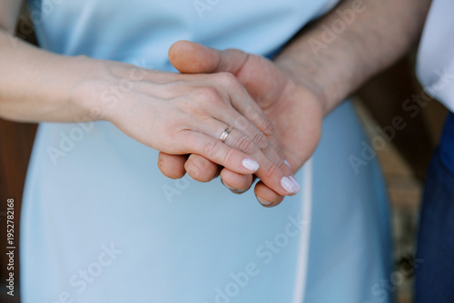 A close-up of the groom holding the bride's hand