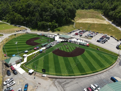 Foto Youth baseball game on turf field in rural Appalachian mountains with families a