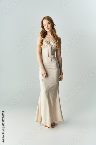Beautiful young woman in elegant dress surrounded by blooming flowers in spring light