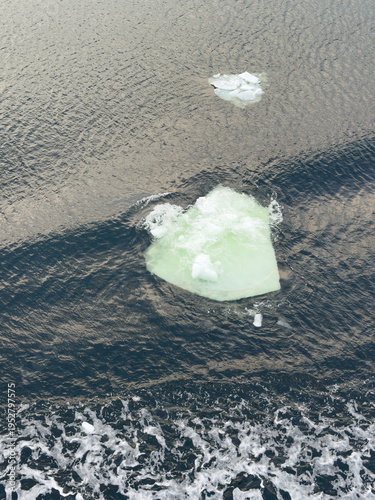 Fotografia An iceberg drifts on the surface of dark water