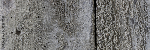 Texture of old cracked concrete wall. Rough gray concrete surface. The gap between the reinforced concrete slabs. Wide panoramic background for design.