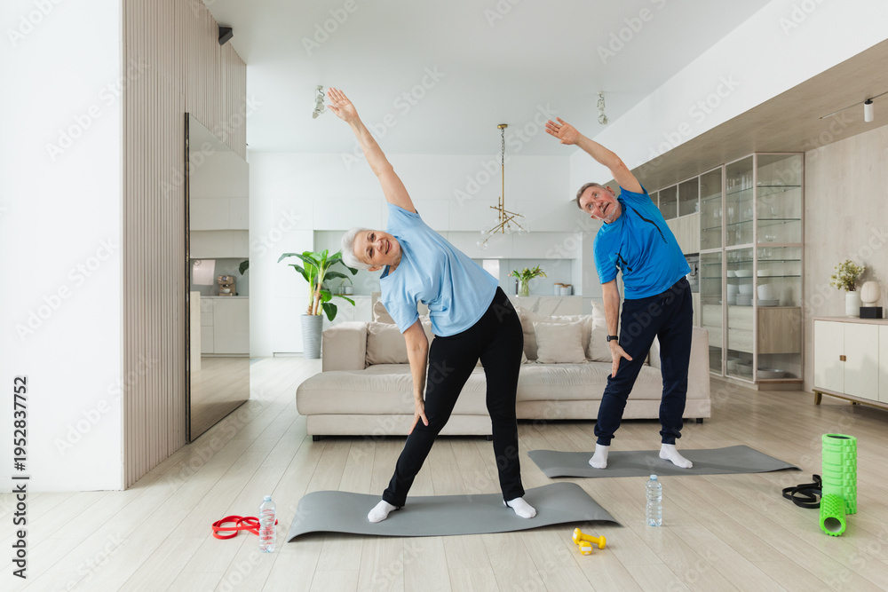 Fototapeta premium Fitness training. Senior mature healthy fit couple doing sports exercise at home. Mid age husband wife have training workout. Health care healthy lifestyle. Workout rehabilitation for old man woman