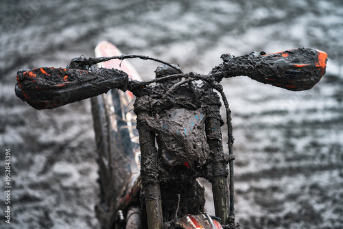 Fotografi Dirty motorbike handlebar covered with mud after motocross competition