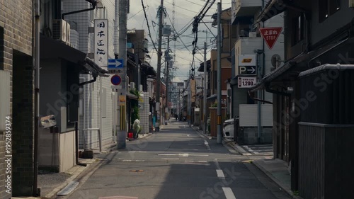 Kyoto street view featuring traditional houses, electric wires, and calm city environment.
