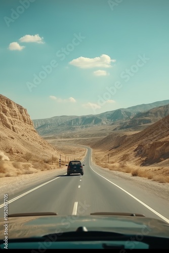 A car driving down a desert road with mountains in the background. Suitable for travel, adventure, and road trip concepts.