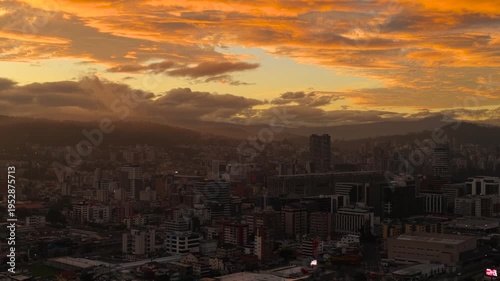 Wallpaper Mural Aerial view of Quito, Ecuador at sunrise with a dramatic orange sky, glowing clouds, and the urban skyline beneath intense early morning light. Torontodigital.ca