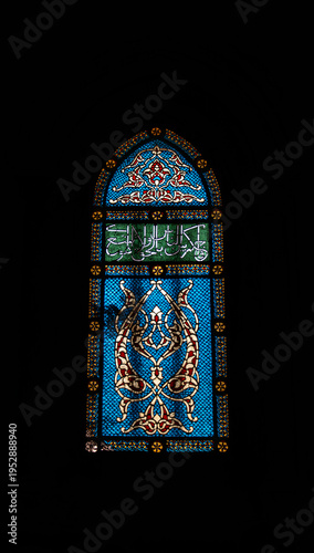 Ornamental stained glass window with Arabic calligraphy and blue patterns