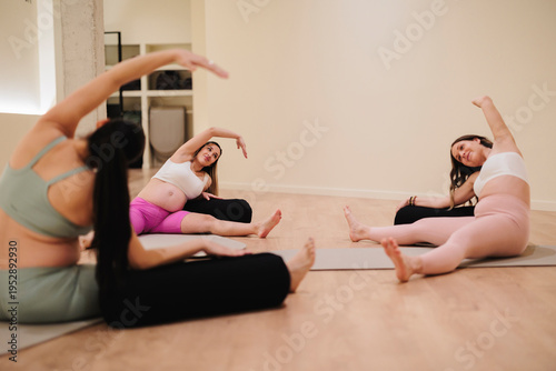 Pregnant women practicing prenatal yoga, focusing on gentle stretching