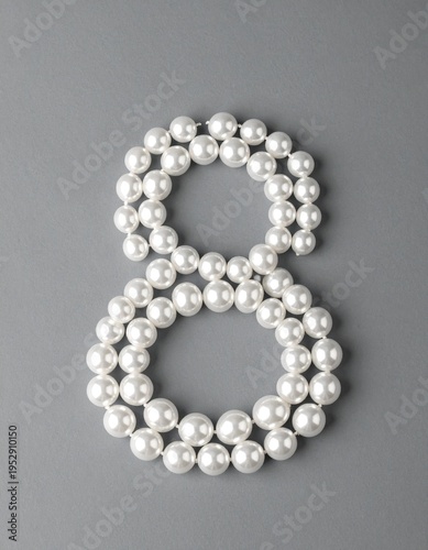 Number 8 made out of small pearls on a neutral solid background