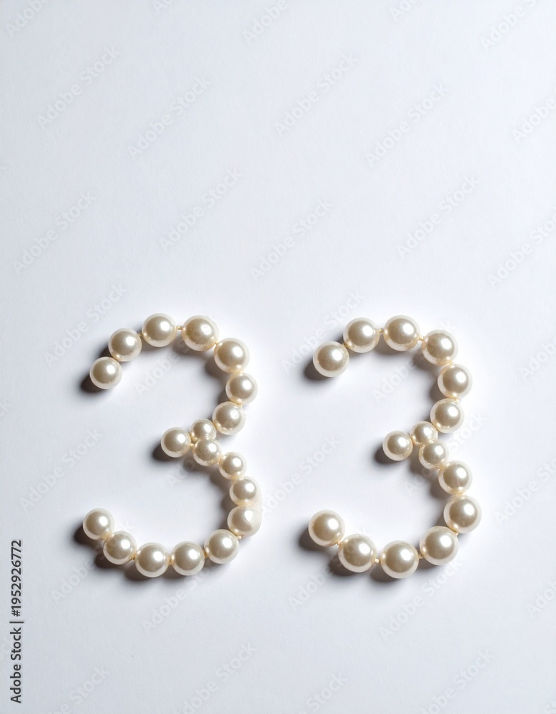 Obraz premium Number 33 made out of small pearls on a neutral solid background