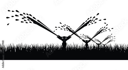 Silhouette of three lawn sprinklers on grassy lawn with water spray