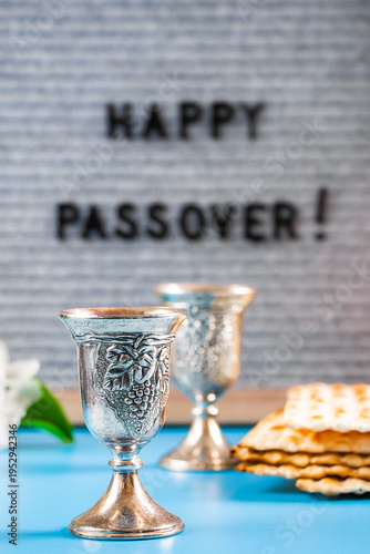 Happy Passover. Metal wine glasses and traditional Jewish matzo bread.