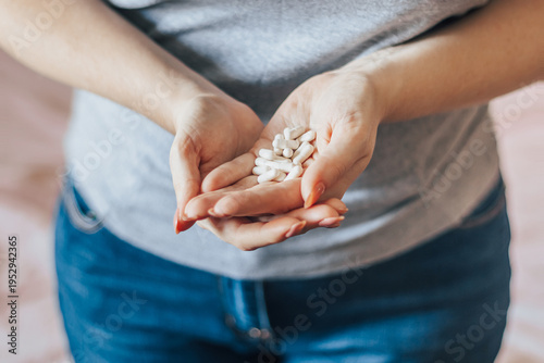 Womans hand is holding pills. Overdose of medicinal capsules in palms close-up.